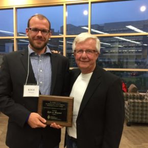 Kyle Wagner holding his award with Dick Peterson