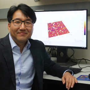 Seungpyo Hong at his desk with a 3D rendered image on his computer