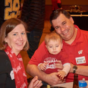 An alumni with their family and child at a School of Pharmacy tailgate party.