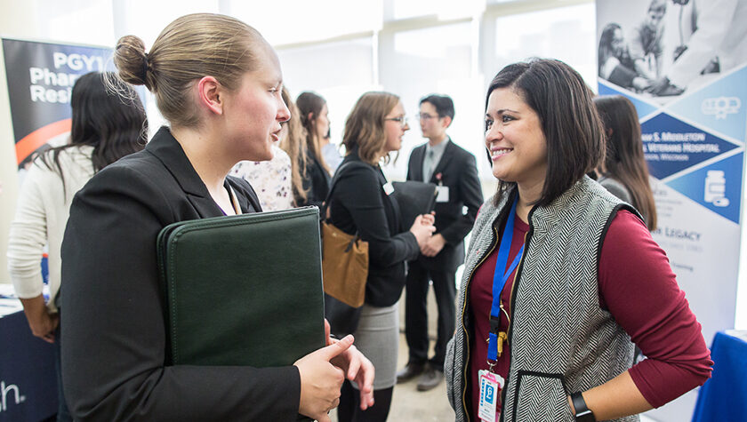 Maria Wopat (PharmD '10) (right) speaking with a student during the School of Pharmacy's 2019 Career Fair.