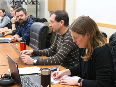 Staff with laptops in front of them during meeting