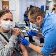 PharmD student Mark Moua gives the Covid vaccine. Photo by Paul L. Newby II