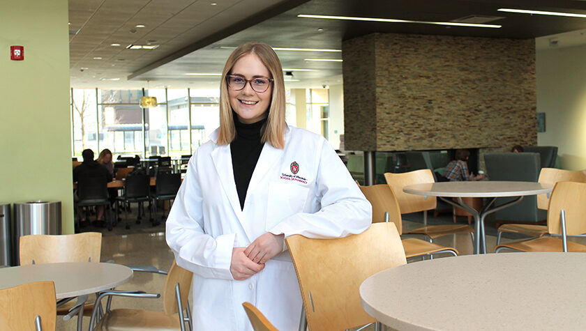 Morgan Oettinger poses for a photo in her white coat.