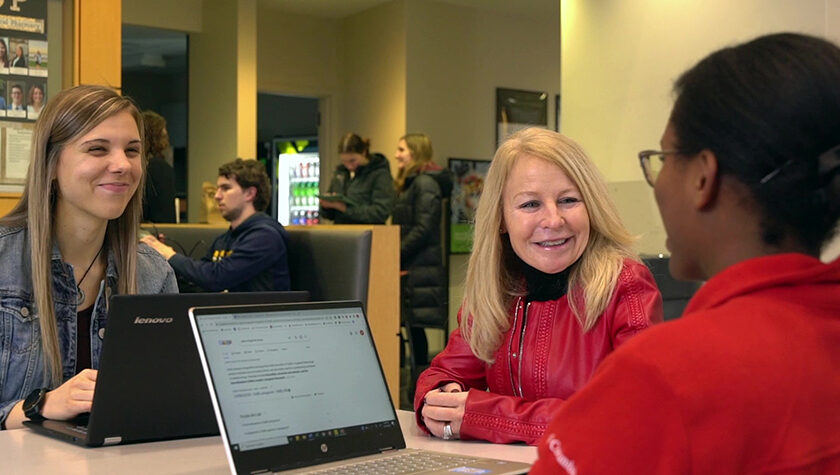 Nancy Gilbride speaking with two PharmD students