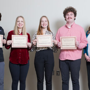 Lukas Kelsey, Jenna Nordin, Kelby Drogemueller, and Sawyer Fleming holding up APhA-ASP Region 4 award certificates, posed with Andrea Porter.