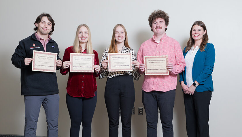 Lukas Kelsey, Jenna Nordin, Kelby Drogemueller, and Sawyer Fleming holding up APhA-ASP Region 4 award certificates, posed with Andrea Porter.