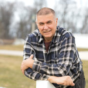 Mark Putzi leans on a post