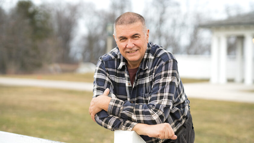 Mark Putzi leans on a post