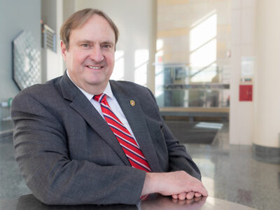 An environmental portrait of Steve Swanson in the sun-brightened atrium of the School of Pharmacy.