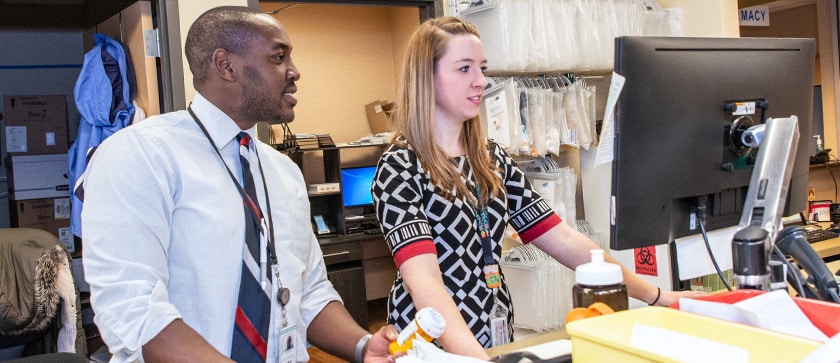A pharmacist at a rural site answers questions for a residency student