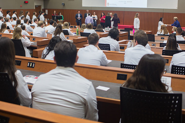 Students and school faculty conducting the pinning ceremony