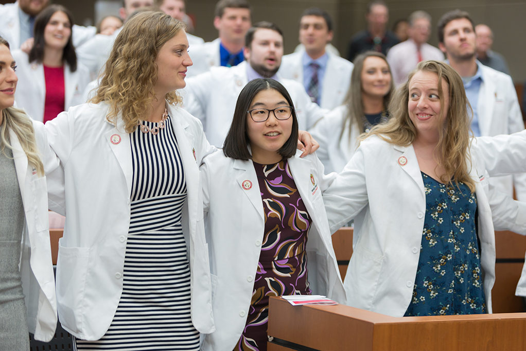 Student pharmacists locking arms during the ceremony
