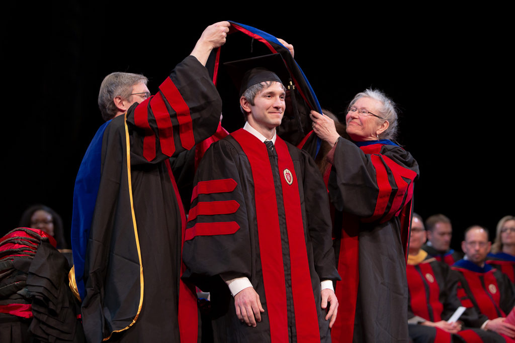 Students receive the hood for their graduation.