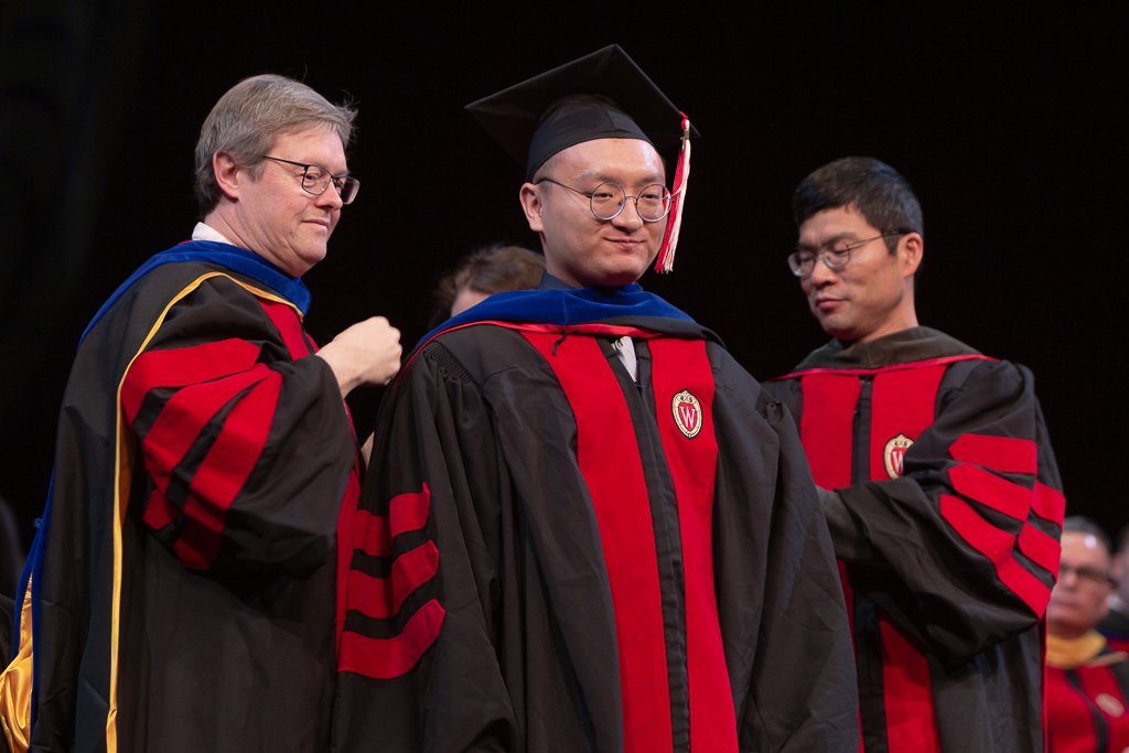 Students receive the hood for their graduation.