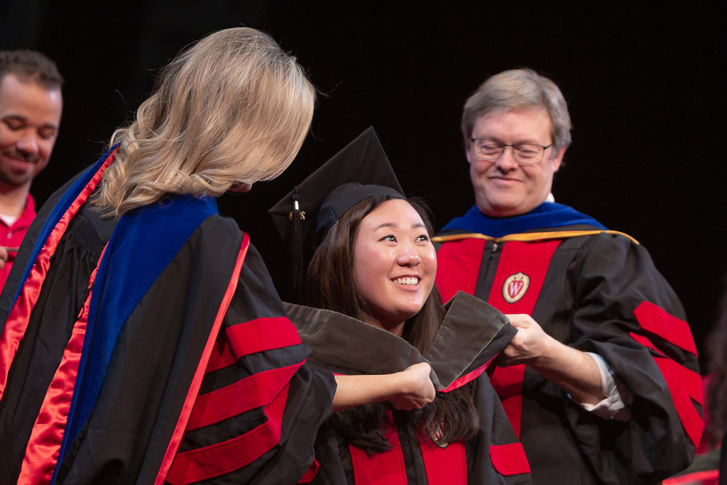 Students receive the hood for their graduation.