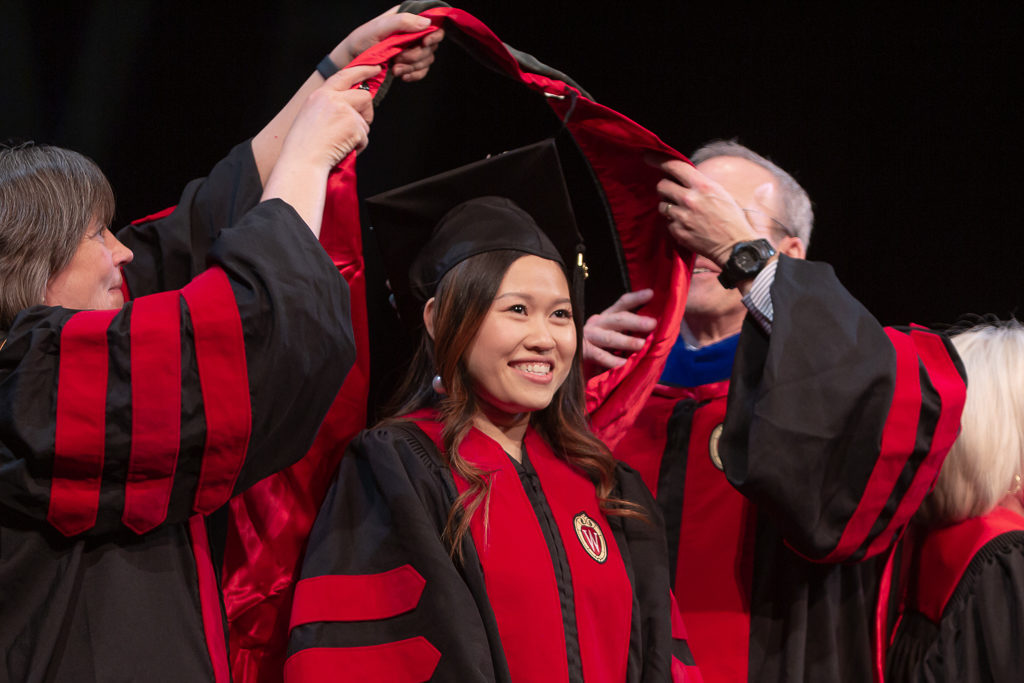 Students receive the hood for their graduation.