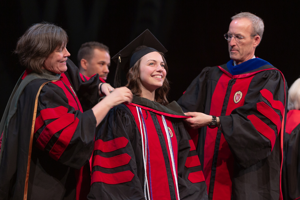 A student is awarded the hood from the school faculty.