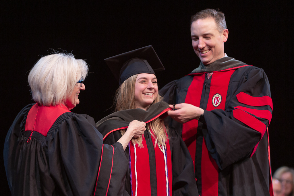 A student is awarded the hood from the school faculty.