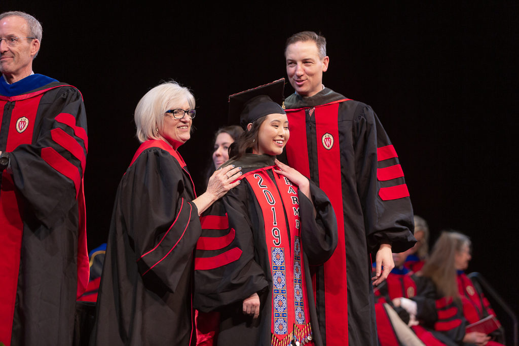 A student is awarded the hood from the school faculty.