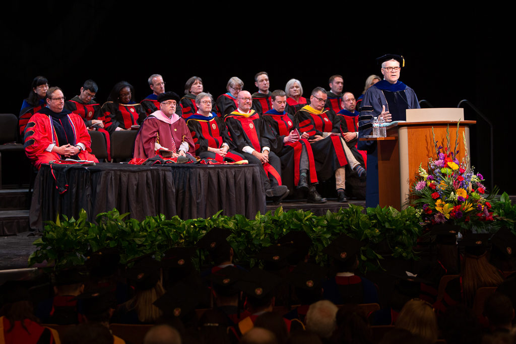 School faculty are with students at the ceremony.