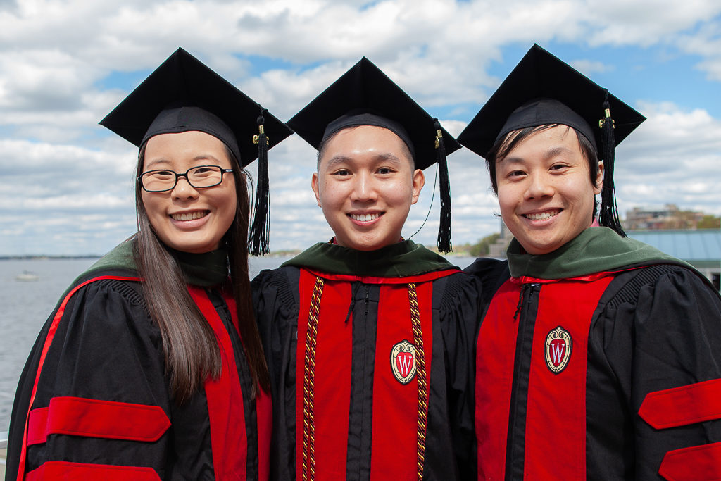 Graduates standing together in their graduation robes for a picture