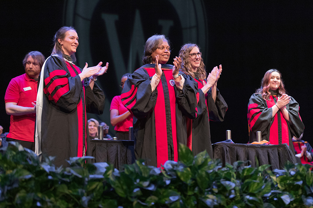Onstage, faculty applaud.
