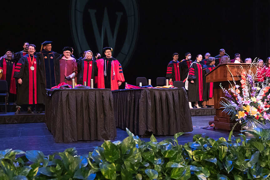 Onstage, faculty also link arms to sing Varsity.