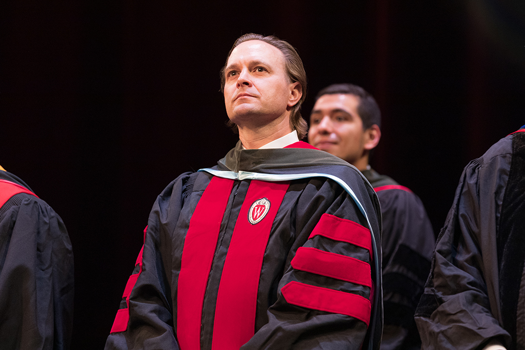 Close-up shot of a professor for school of pharmacy sitting down at hooding ceremony