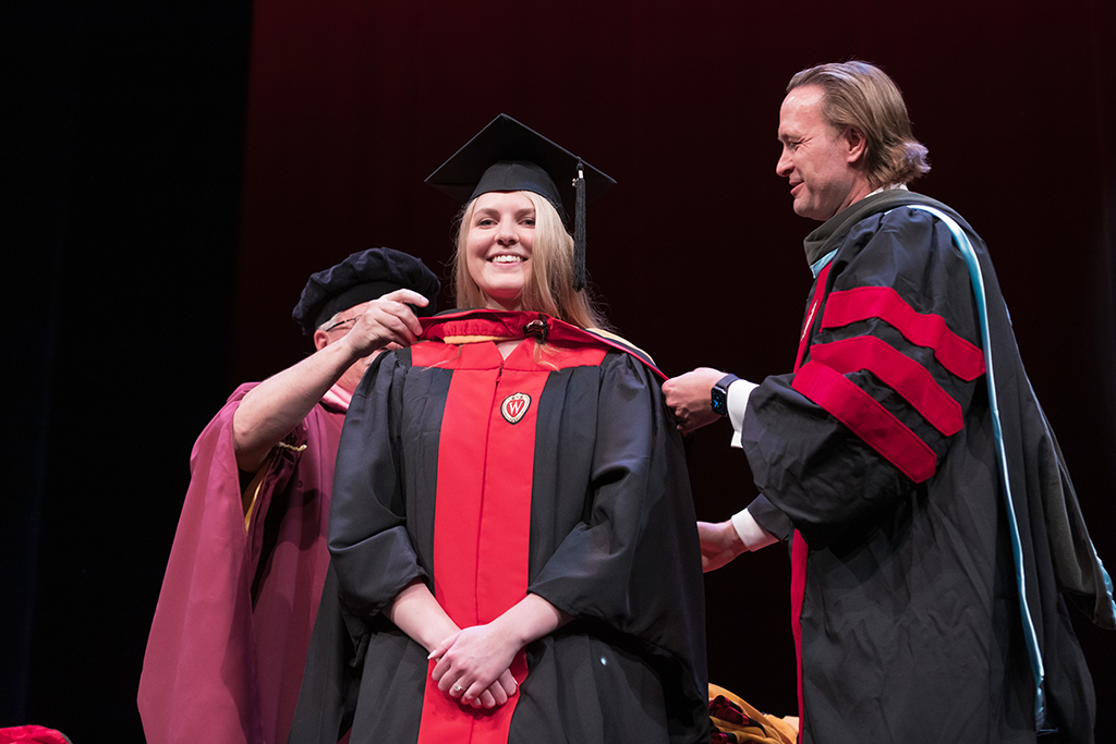 Assistant Dean Melgardt deVilliers and another professor putting the hood on a graduate student