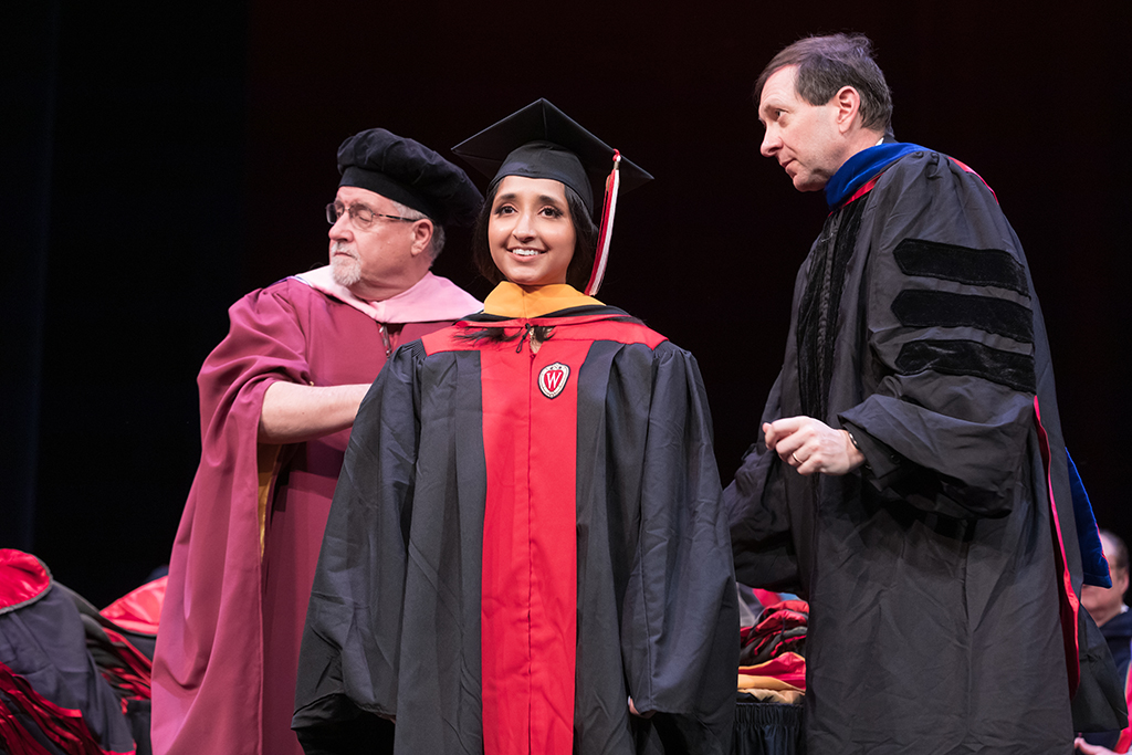 Assistant Dean Melgardt deVilliers and another professor putting the hood on a graduate student