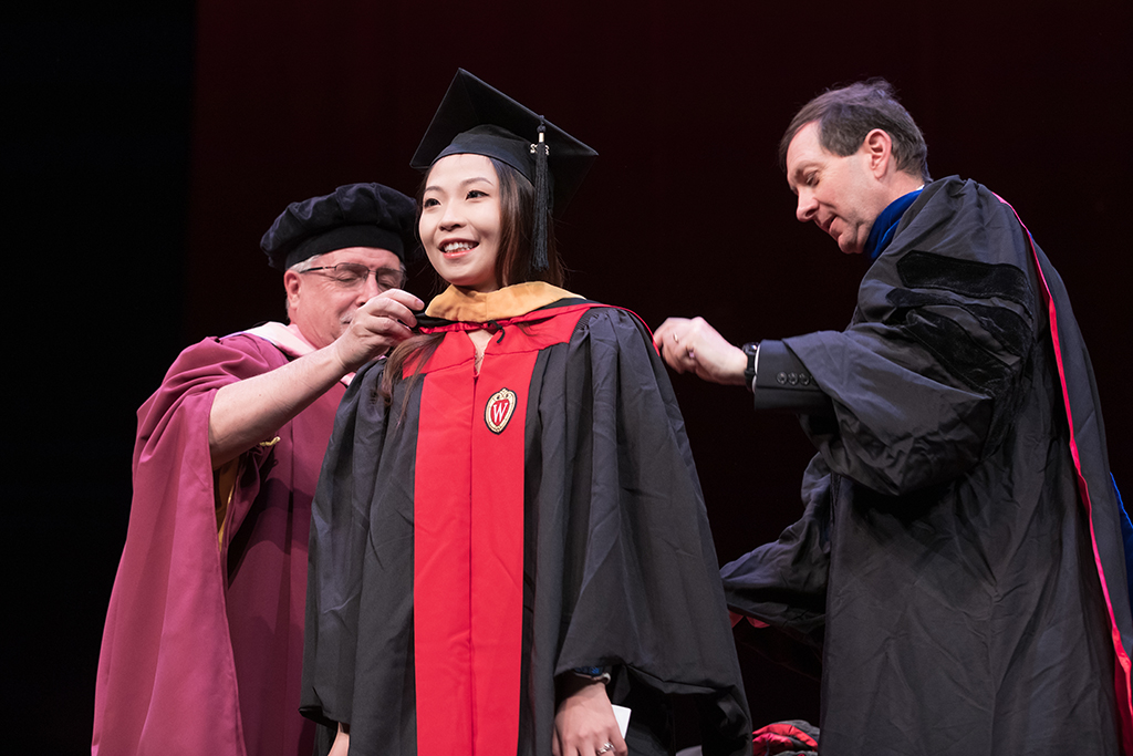 Assistant Dean Melgardt deVilliers and another professor putting the hood on a graduate student