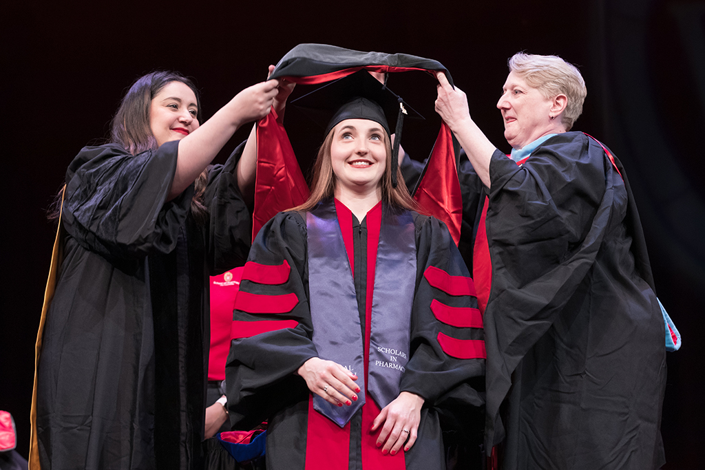 Class of 2022 PharmD graduate Maija Anderson Doran receives her hood from Professors Marina Maes and Karen Kopacek