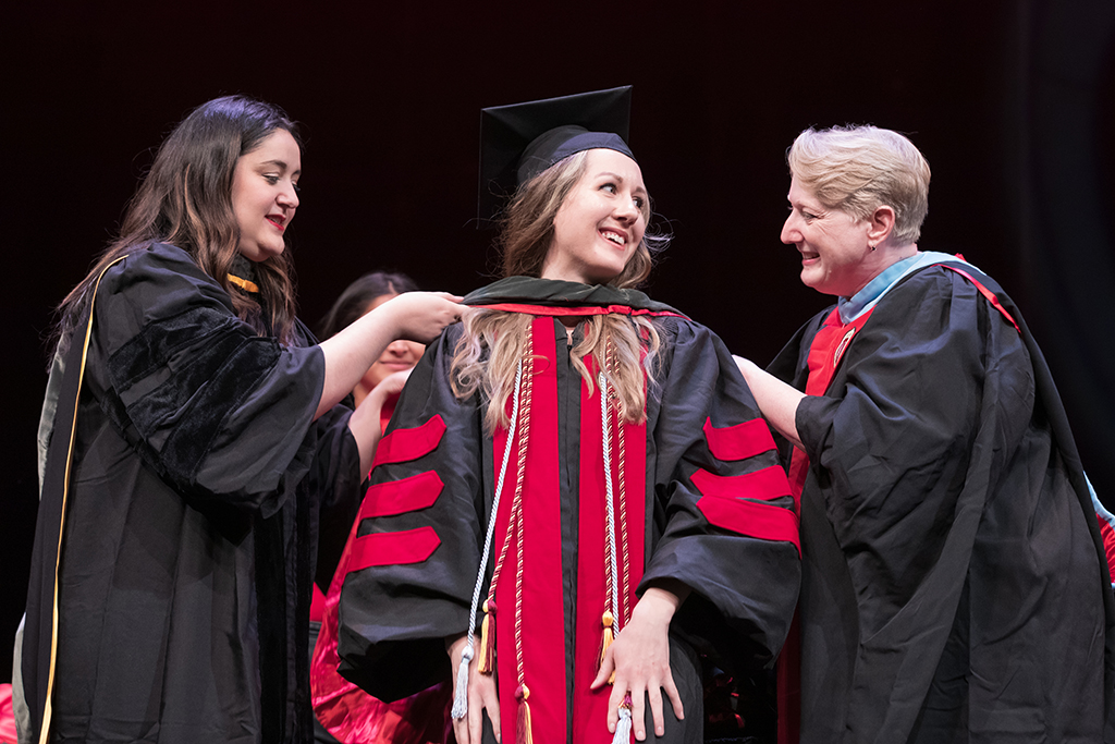 Class of 2022 PharmD graduate Kaitlin Babula receives her hood from Professors Marina Maes and Karen Kopacek