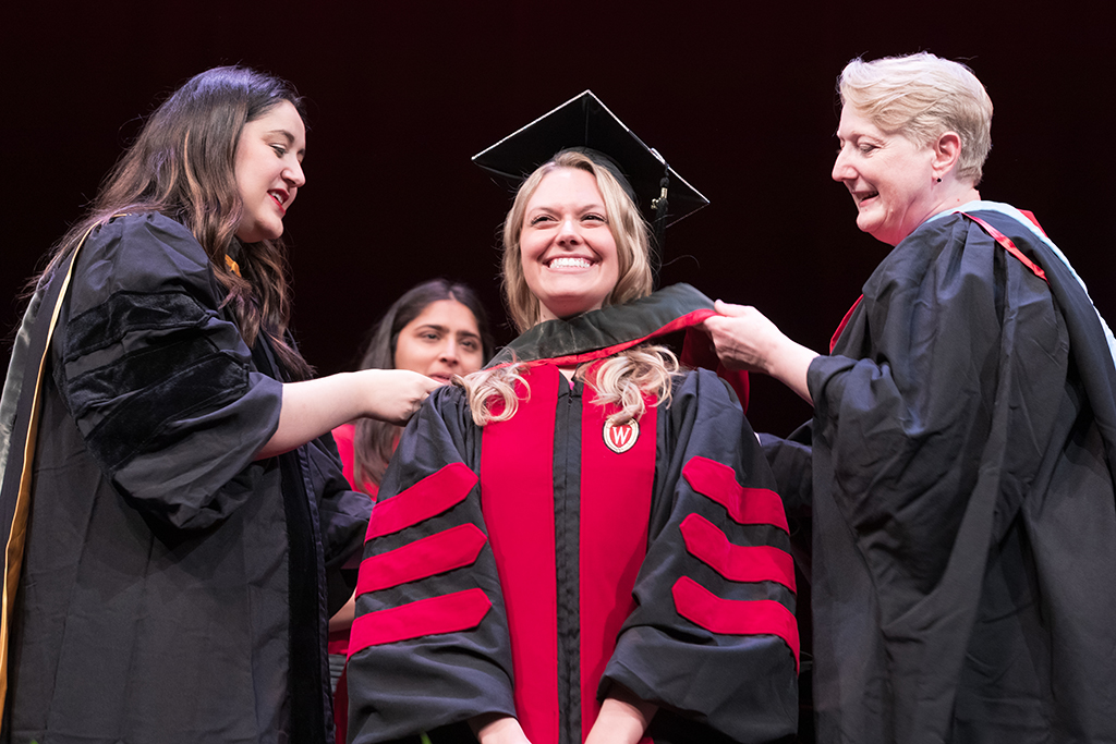 Class of 2022 PharmD graduate Emily Fox receives her hood from Professors Marina Maes and Karen Kopacek