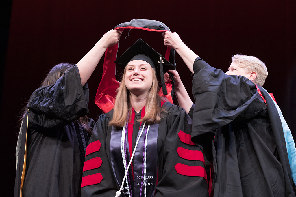 Class of 2022 PharmD graduate Stephanie Garvin receives her hood from Professors Marina Maes and Karen Kopacek