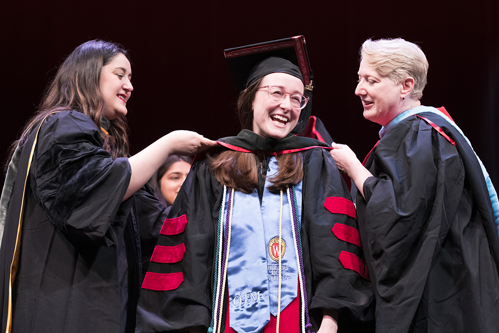 Class of 2022 PharmD graduate Darina Georgieva receives her hood from professors Marina Maes and Karen Kopacek