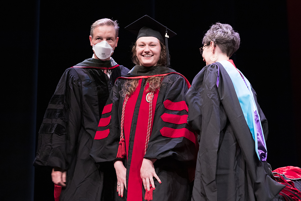 Class of 2022 PharmD graduate Lauren Johnson receives her hood from Professor John Dopp and Advisor Rebecca Beebe