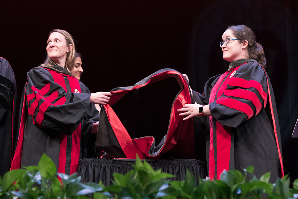 Professors Kate Rotzenburg and Amanda Margolis wait at the ready for the next graduating PharmD student