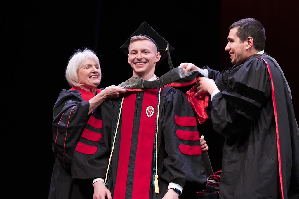 Class of 2022 PharmD graduate Nick Olszewski receives his hood from Professors Bonnie Fingerhut and Ed Portillo