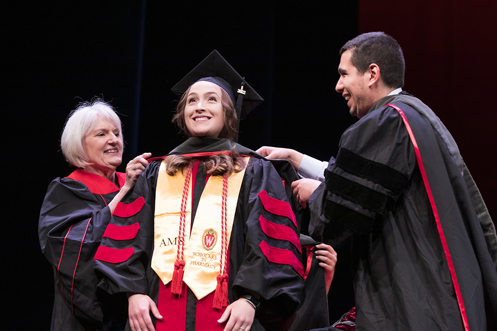 Class of 2022 PharmD graduate Lindsey Otto receives her hood from Professors Bonnie Fingerhut and Ed Portillo