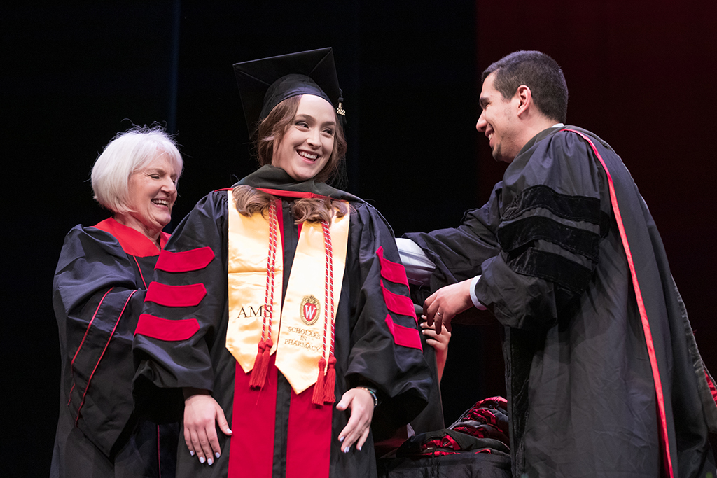 Class of 2022 PharmD graduate Lindsey Otto receives her hood from Professors Bonnie Fingerhut and Ed Portillo