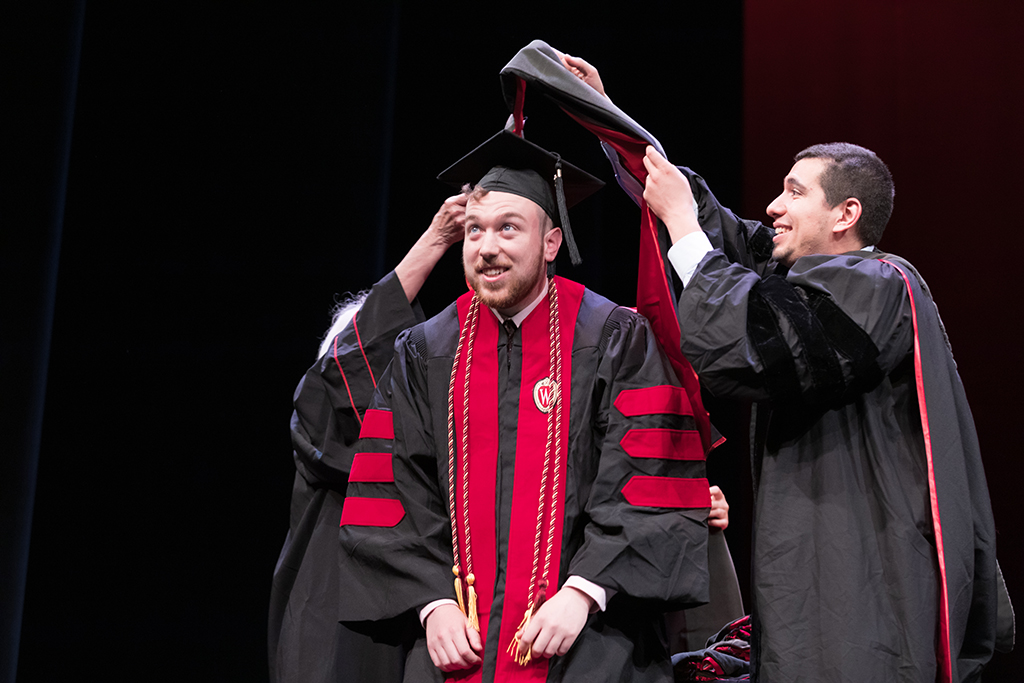 Class of 2022 PharmD graduate Alexander Reiter receives his hood from Professors Bonnie Fingerhut and Ed Portillo