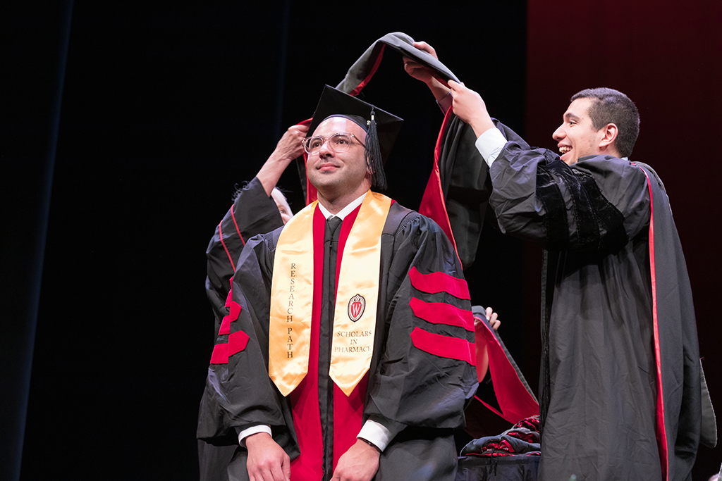 Class of 2022 PharmD graduate Dan Smelter receives his hood from Professors Bonnie Fingerhut and Ed Portillo