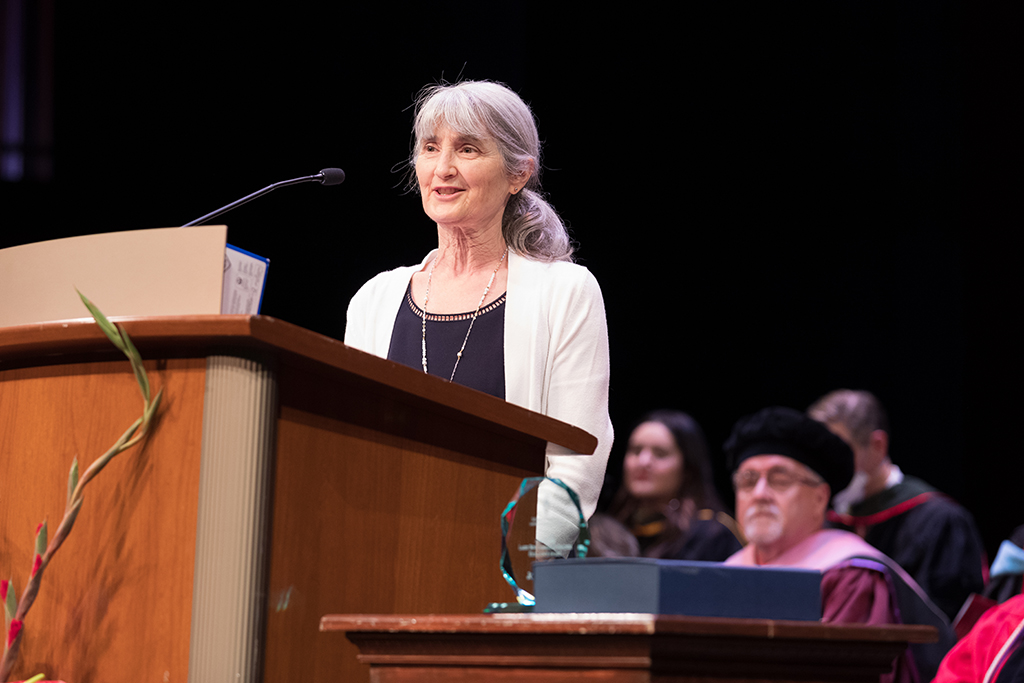 SoP faculty speaking at the podium for 2022 Hooding Ceremony