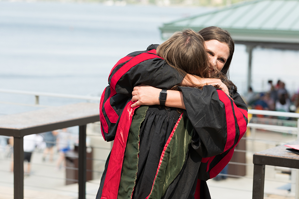 Class of 2022 PharmD graduate Lauren Streets and her classmate celebrate the 2022 Hooding Ceremony at Memorial Union Terrace