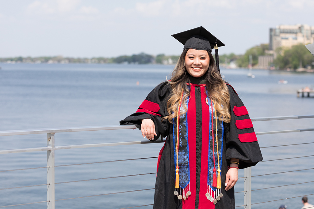 Class of 2022 PharmD graduate Der Lor poses in her cap and gown at Memorial Union Terrace after the Hooding Ceremony