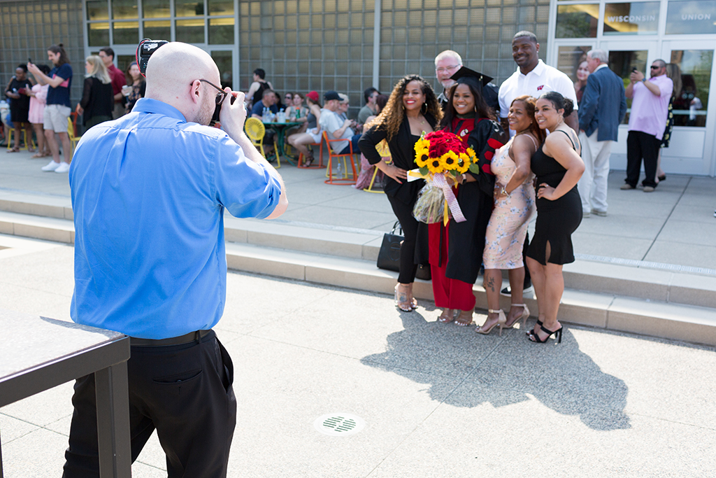 Silvya Velez Pache poses in her cap and gown next to family members at the Memorial Union after the 2022 School of Pharmacy Hooding Ceremony