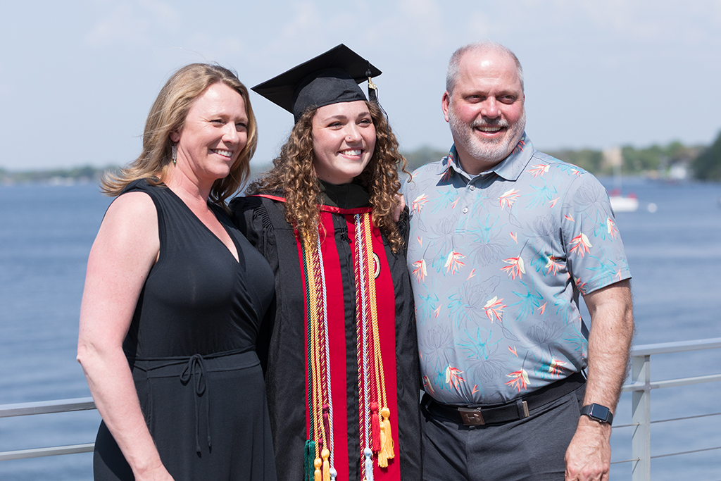 PharmD graduate Sydney Ertz (Class of 2022) poses for a picture by the lake after the 2022 School of Pharmacy Hooding Ceremony