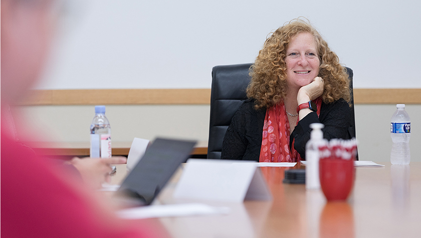 Chancellor Mnookin smiles at a board room table