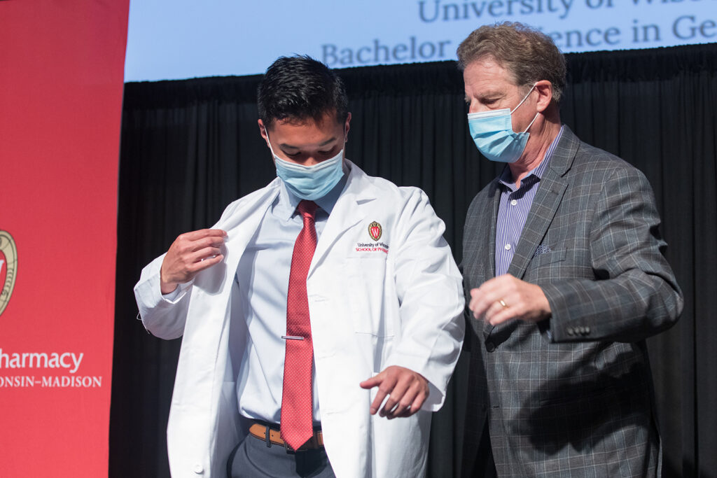 Student wearing their white coat on-stage